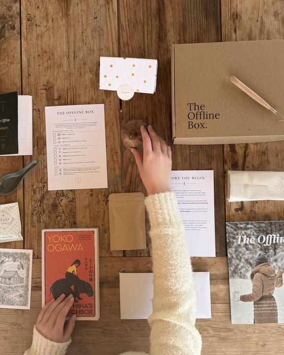 A past MERRI box opened on a table, full of tissue-wrapped things